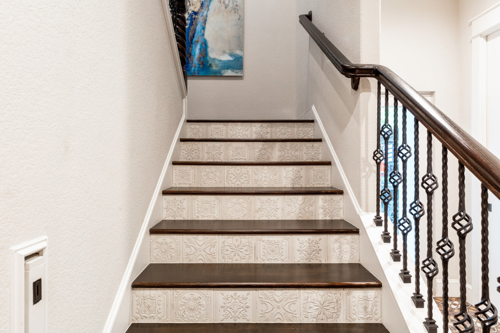 Imagen de escalera en L mediterránea de tamaño medio con escalones de madera, contrahuellas con baldosas y/o azulejos y barandilla de madera
