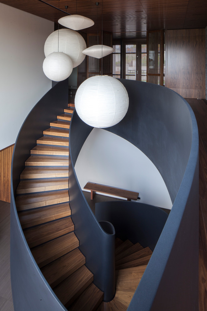 This is an example of an expansive modern wood spiral staircase in San Francisco with concrete risers.