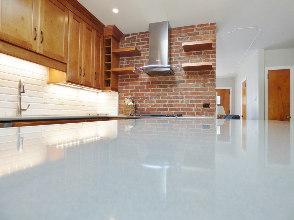 Inspiration for a transitional l-shaped porcelain tile eat-in kitchen remodel with an undermount sink, recessed-panel cabinets, medium tone wood cabinets, quartz countertops, white backsplash, subway tile backsplash, stainless steel appliances and an island