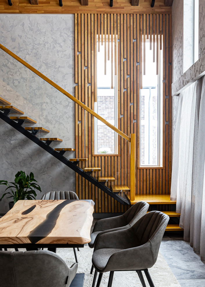 Foto di un ampio soggiorno minimal aperto con pareti grigie, pavimento in gres porcellanato, camino classico, cornice del camino in pietra e pavimento grigio