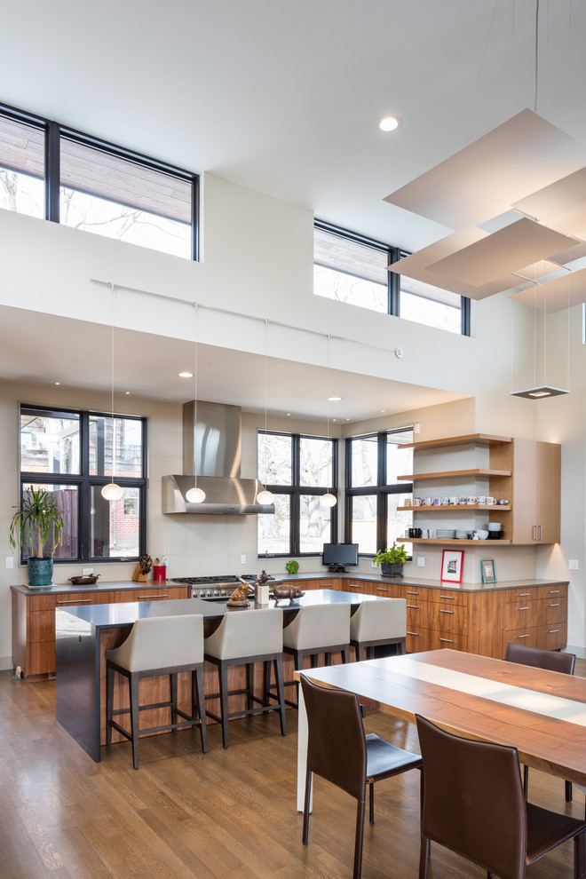 Large contemporary l-shaped open plan kitchen in Kansas City with flat-panel cabinets, dark wood cabinets, quartz benchtops, beige splashback, stainless steel appliances, dark hardwood floors, with island and brown floor.
