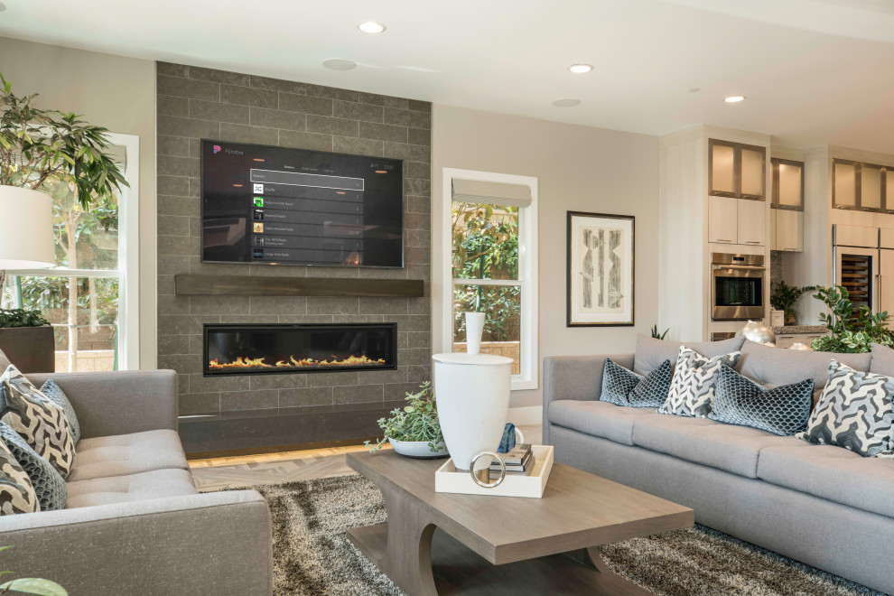 Photo of a large contemporary open concept living room in Toronto with a music area, medium hardwood floors, a hanging fireplace, a tile fireplace surround and a wall-mounted tv.