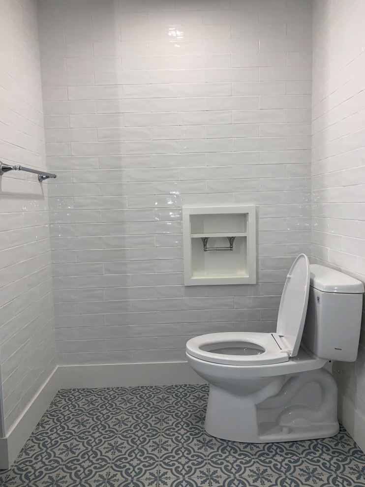 Example of a mid-sized transitional 3/4 white tile and subway tile alcove shower design in Boston with shaker cabinets, gray cabinets, a two-piece toilet, an undermount sink, quartz countertops, a hinged shower door and gray countertops