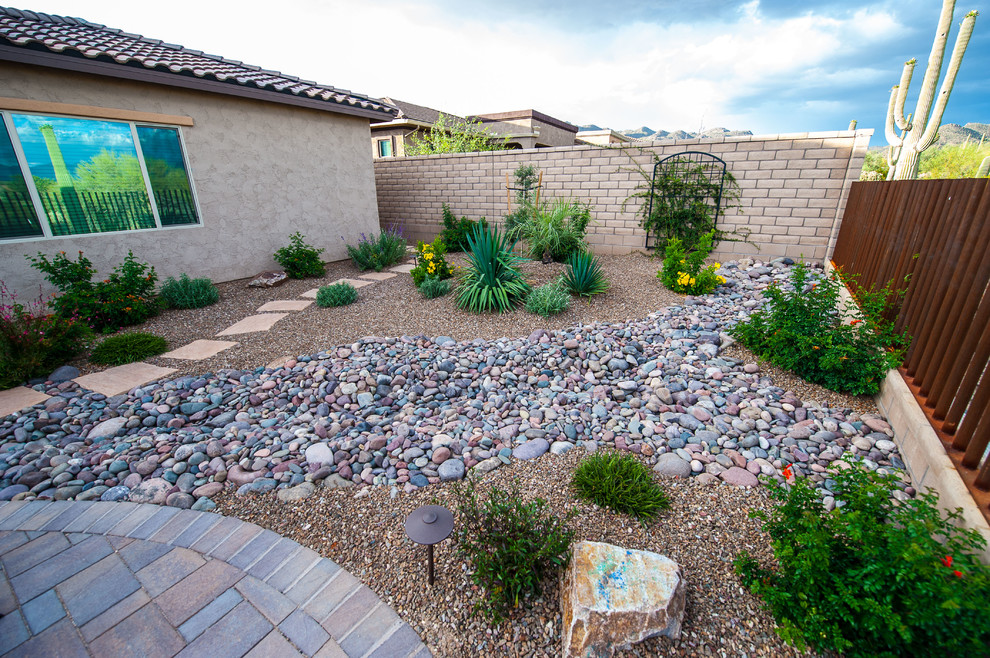 Inspiration for a mid-sized backyard partial sun xeriscape for summer in Phoenix with a water feature and gravel.
