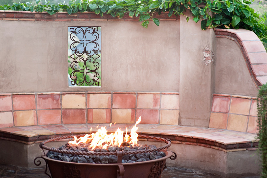Mid-sized mediterranean backyard patio in San Diego with a fire feature and no cover.