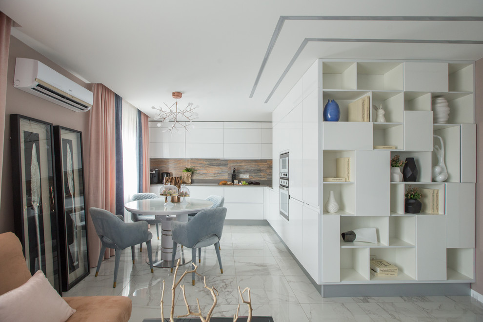 Photo of a contemporary l-shaped open plan kitchen in Other with flat-panel cabinets, white cabinets, brown splashback, white appliances, no island and white floor.