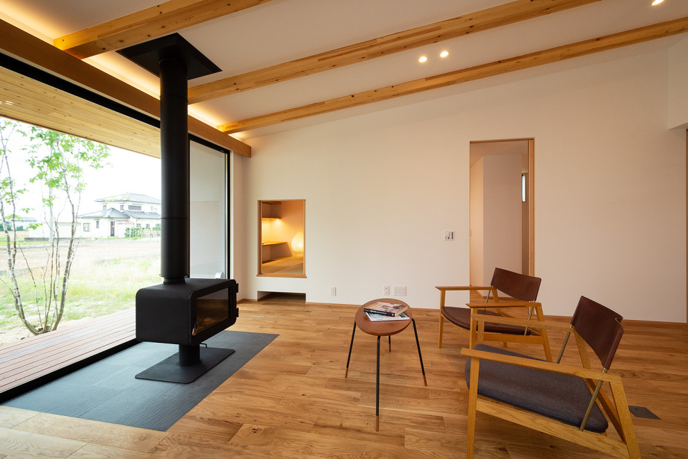 Идея дизайна: большая открытая гостиная комната в скандинавском стиле с белыми стенами, паркетным полом среднего тона, печью-буржуйкой, фасадом камина из плитки, отдельно стоящим телевизором и потолком с обоями