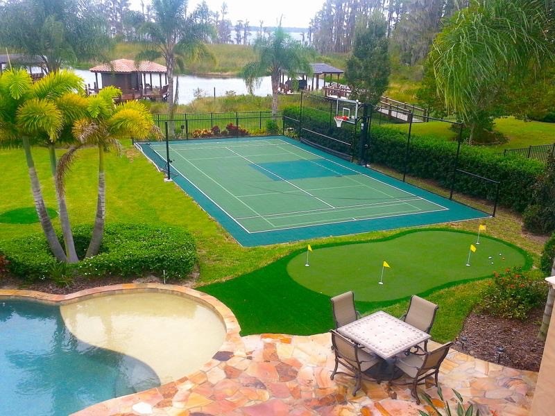 Large tropical backyard full sun outdoor sport court in New York with with outdoor playset.