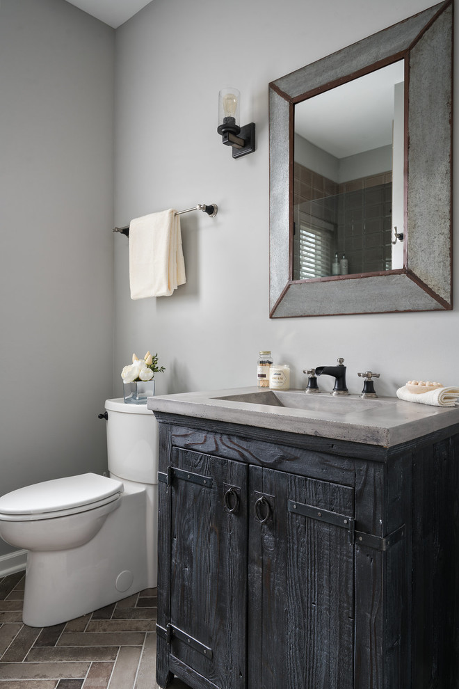 Photo of a small powder room in Columbus with furniture-like cabinets, black cabinets, a one-piece toilet, grey walls, porcelain floors, an integrated sink, concrete benchtops and multi-coloured floor.