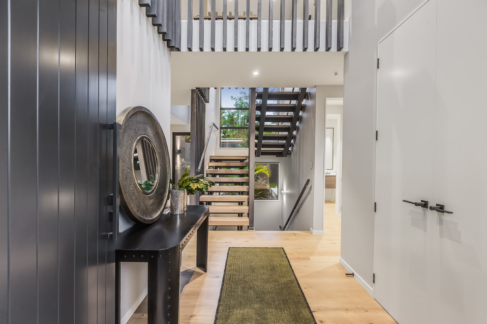 Mid-sized contemporary foyer in Auckland with white walls, light hardwood floors, a pivot front door and a gray front door.