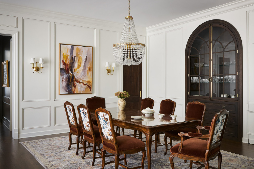 Foto di una sala da pranzo classica chiusa con pareti bianche, parquet scuro, pavimento marrone e pannellatura