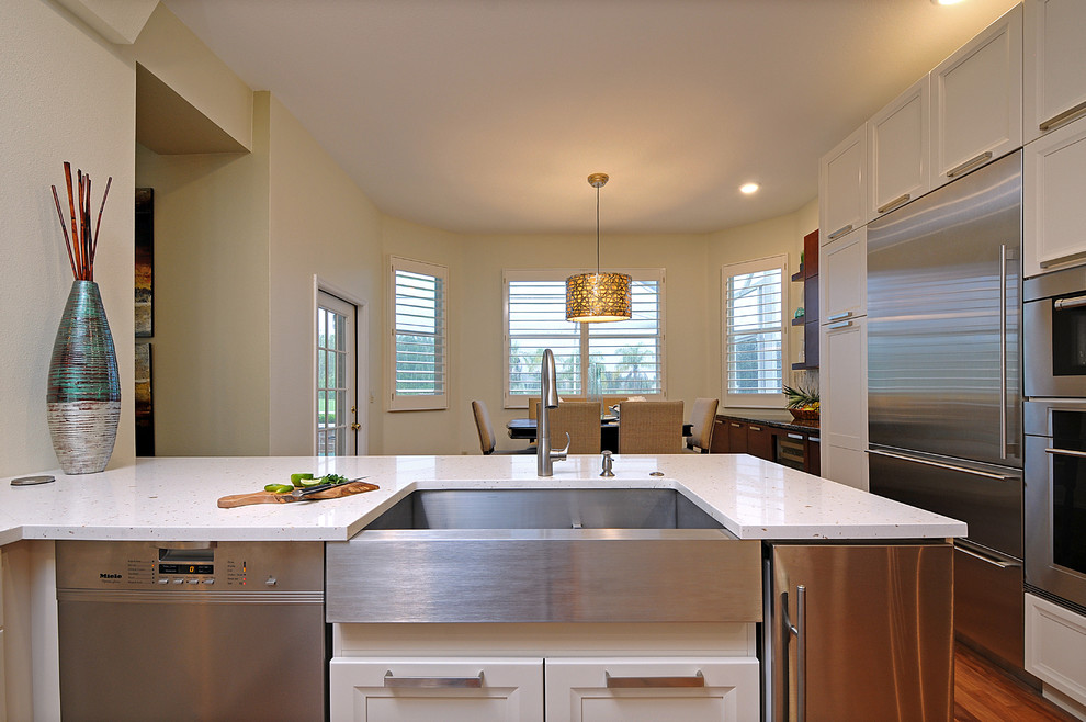 Inspiration for a large transitional l-shaped dark wood floor open concept kitchen remodel in Tampa with a farmhouse sink, gray backsplash, matchstick tile backsplash, stainless steel appliances and an island
