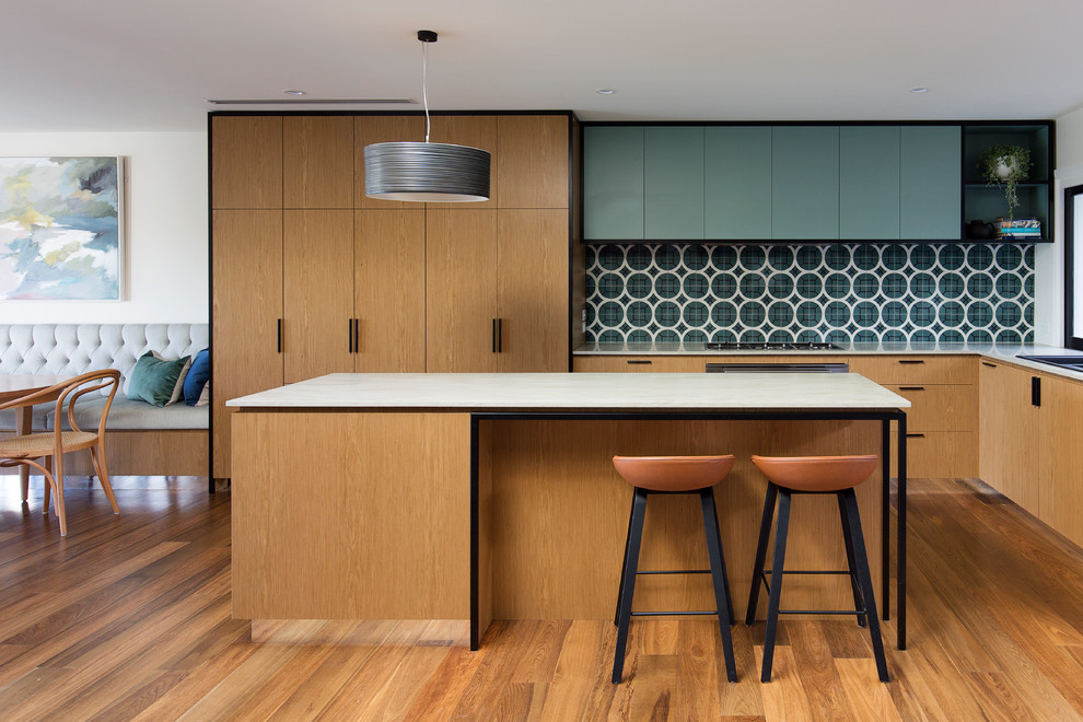 Photo of a contemporary l-shaped eat-in kitchen in Sydney with a double-bowl sink, flat-panel cabinets, medium wood cabinets, blue splashback, stainless steel appliances, medium hardwood floors, with island and brown floor.