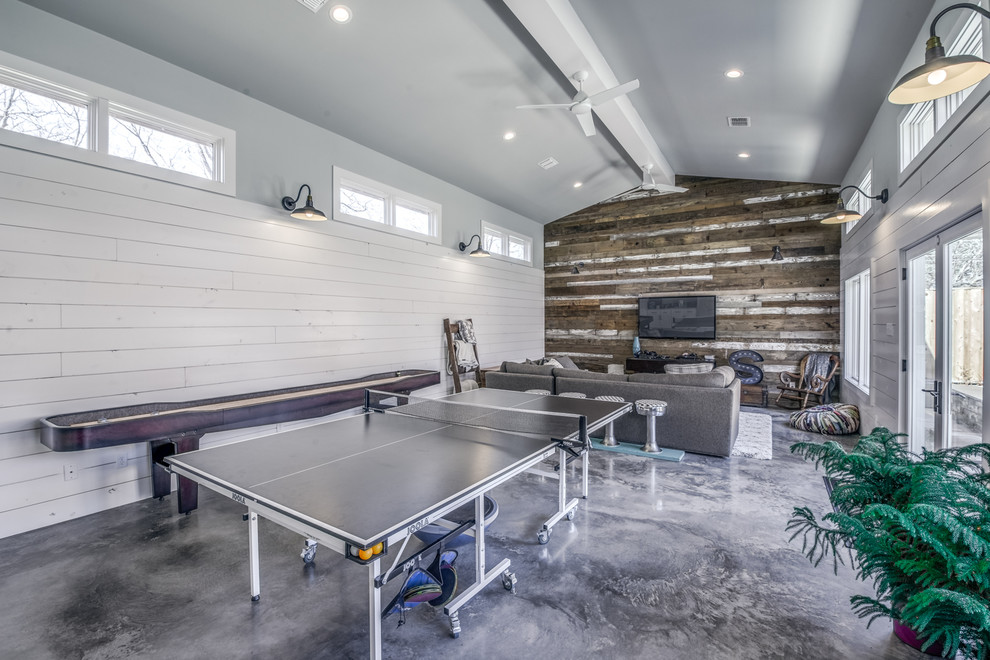 Inspiration for a large country open concept family room in Austin with a game room, white walls, concrete floors and a wall-mounted tv.