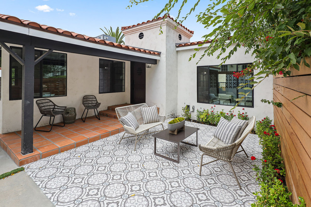 Inspiration for a mid-sized transitional backyard tile patio remodel in Los Angeles with a roof extension