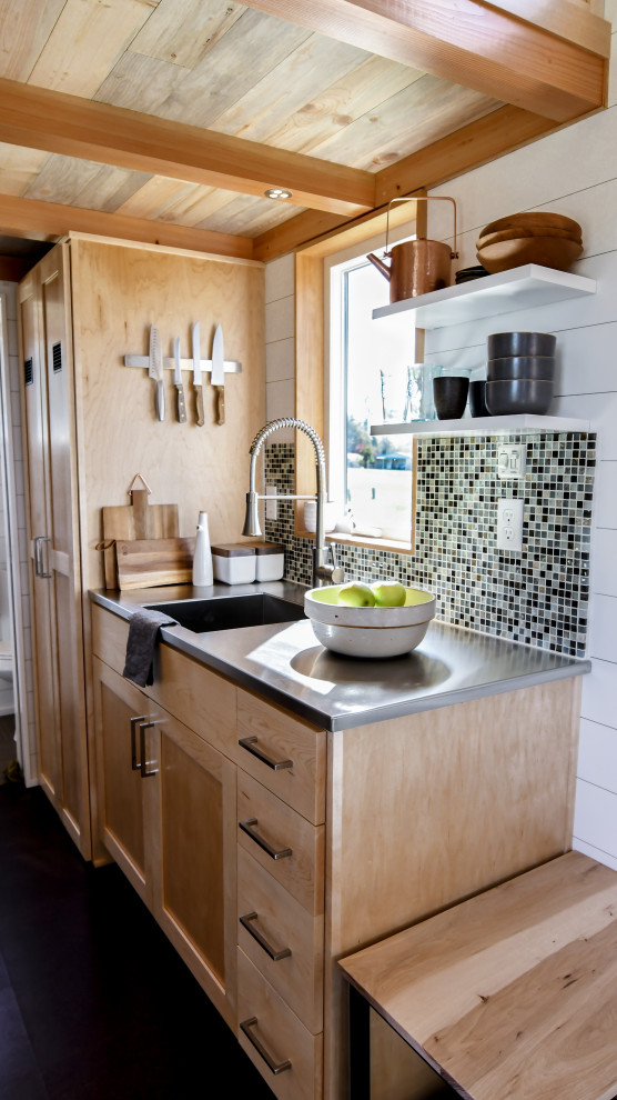This is an example of a small country galley open plan kitchen in Other with an integrated sink, shaker cabinets, light wood cabinets, stainless steel benchtops, green splashback, mosaic tile splashback, cork floors, no island, black floor, grey benchtop and wood.