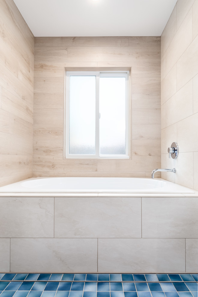 Large transitional master bathroom in San Francisco with flat-panel cabinets, a japanese tub, a shower/bathtub combo, a two-piece toilet, beige tile, a vessel sink, a hinged shower door and blue benchtops.