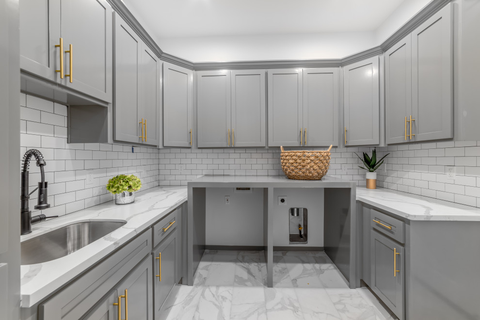 Inspiration for a large transitional u-shaped dedicated laundry room in Sacramento with an undermount sink, shaker cabinets, grey cabinets, quartz benchtops, ceramic floors, a side-by-side washer and dryer and white benchtop.