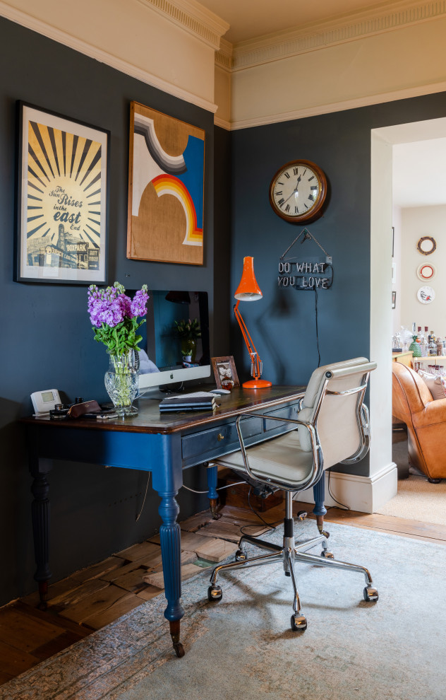 Mittelgroßes Eklektisches Arbeitszimmer mit grauer Wandfarbe, braunem Holzboden und freistehendem Schreibtisch in London