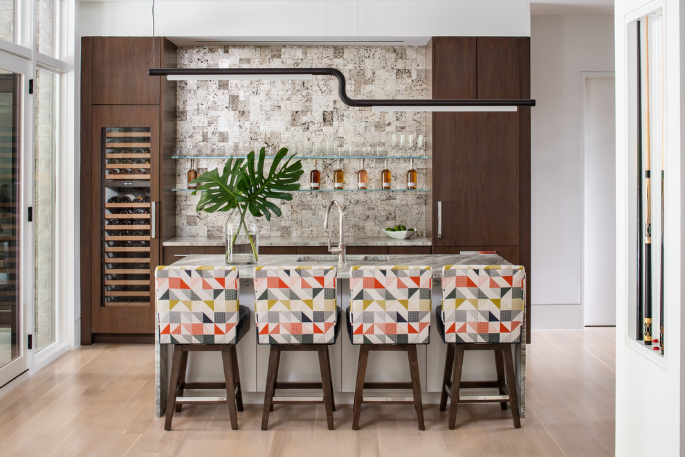 Photo of a contemporary single-wall seated home bar in DC Metro with an undermount sink, flat-panel cabinets, dark wood cabinets, multi-coloured splashback, light hardwood floors, beige floor and multi-coloured benchtop.