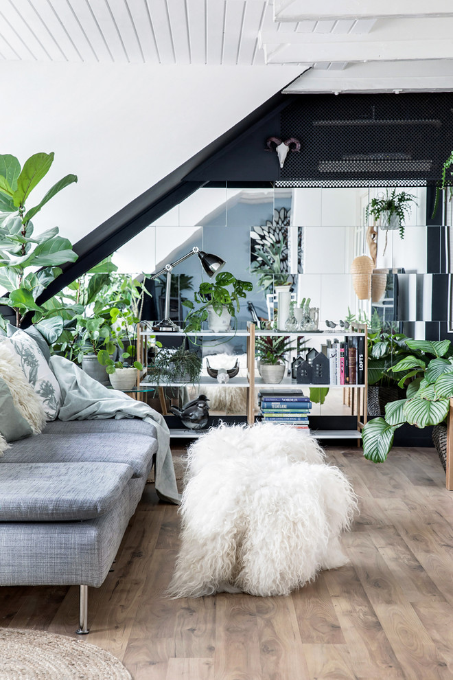 This is an example of a mid-sized eclectic enclosed living room in Copenhagen with black walls, laminate floors and brown floor.
