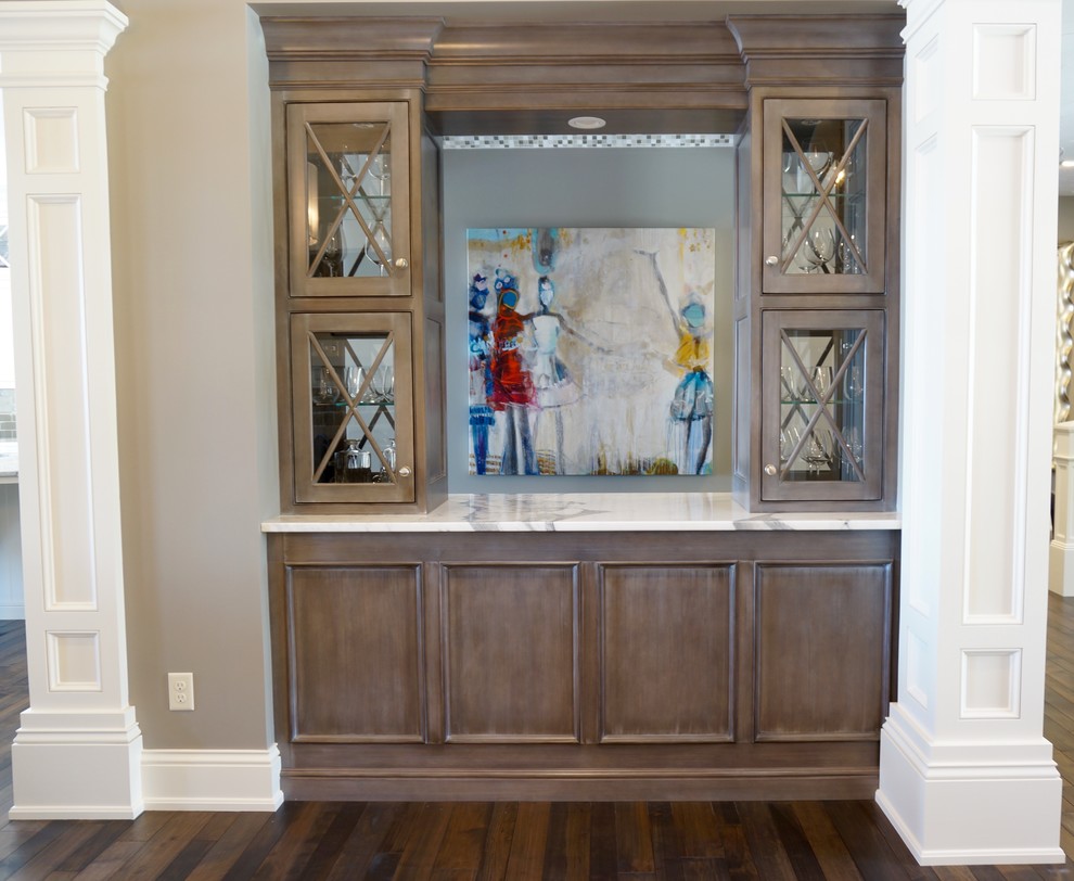 Inspiration for a mid-sized arts and crafts galley wet bar in Cleveland with no sink, glass-front cabinets, grey cabinets, marble benchtops, bamboo floors, brown floor and grey benchtop.