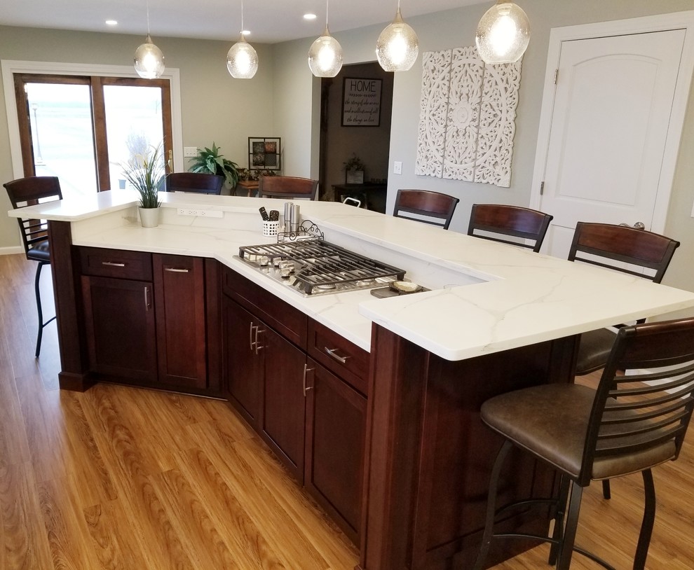 Large transitional l-shaped medium tone wood floor and brown floor open concept kitchen photo in Chicago with a double-bowl sink, shaker cabinets, white cabinets, quartzite countertops, white backsplash, stainless steel appliances and an island