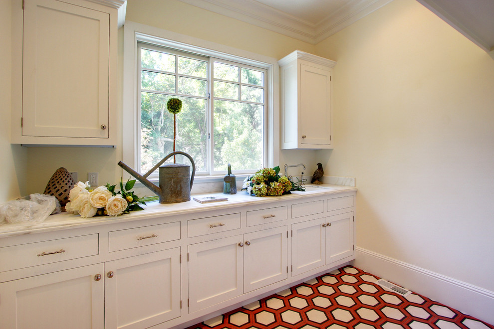 Inspiration for a traditional laundry room in Los Angeles with white cabinets.