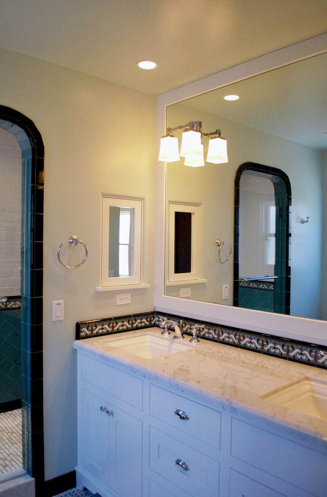 This is an example of a mediterranean 3/4 bathroom in San Diego with shaker cabinets, white cabinets, multi-coloured tile, ceramic tile, marble benchtops, green walls, mosaic tile floors and an undermount sink.