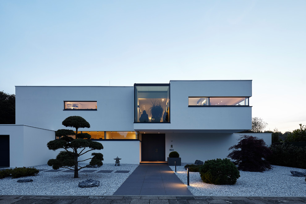 Mid-sized modern two-storey stucco white house exterior in Cologne with a flat roof.