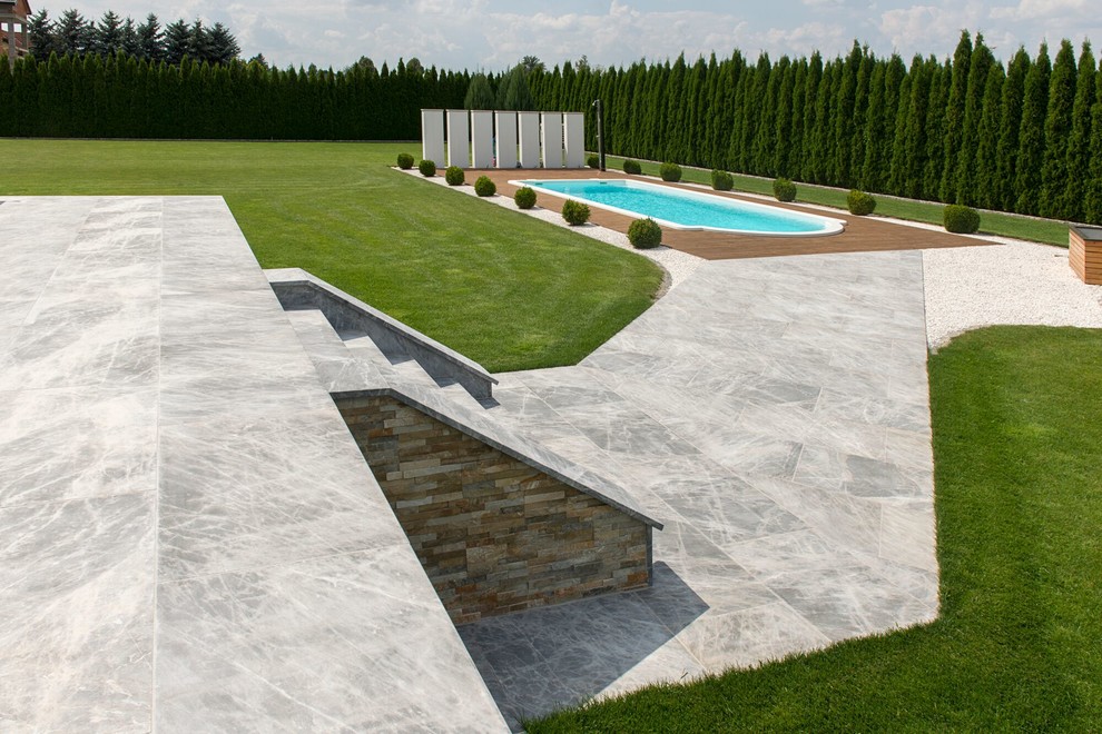 Pool - large contemporary backyard stone and custom-shaped lap pool idea