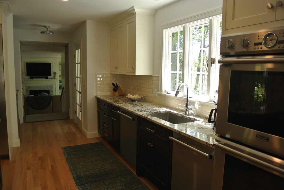 Transitional light wood floor eat-in kitchen photo in Boston with an undermount sink, shaker cabinets, granite countertops, white backsplash, subway tile backsplash, stainless steel appliances and an island