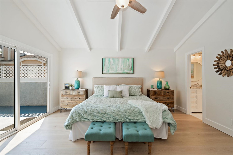 Design ideas for a beach style master bedroom in Los Angeles with white walls, light hardwood floors, no fireplace, beige floor and exposed beam.