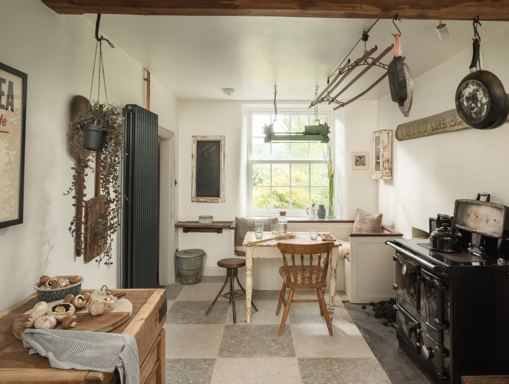 На фото: кухня-столовая среднего размера в стиле кантри с полом из сланца, серым полом и балками на потолке