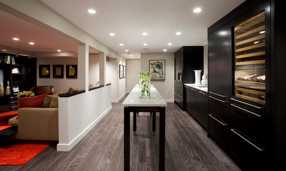 This is an example of a large contemporary single-wall wet bar in Boston with an undermount sink, flat-panel cabinets, dark wood cabinets, granite benchtops, dark hardwood floors and brown floor.