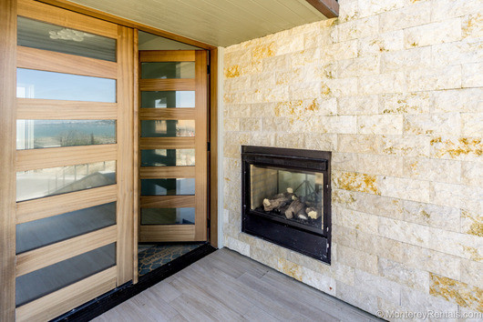 Example of a large minimalist porcelain tile and brown floor front door design with multicolored walls and a light wood front door