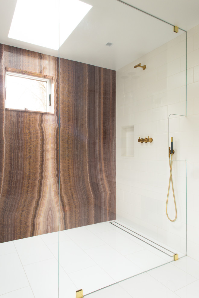 Mid-sized modern master bathroom in New York with flat-panel cabinets, medium wood cabinets, an alcove shower, a trough sink, white floor, brown tile, multi-coloured tile, stone slab, onyx benchtops, a hinged shower door and brown benchtops.