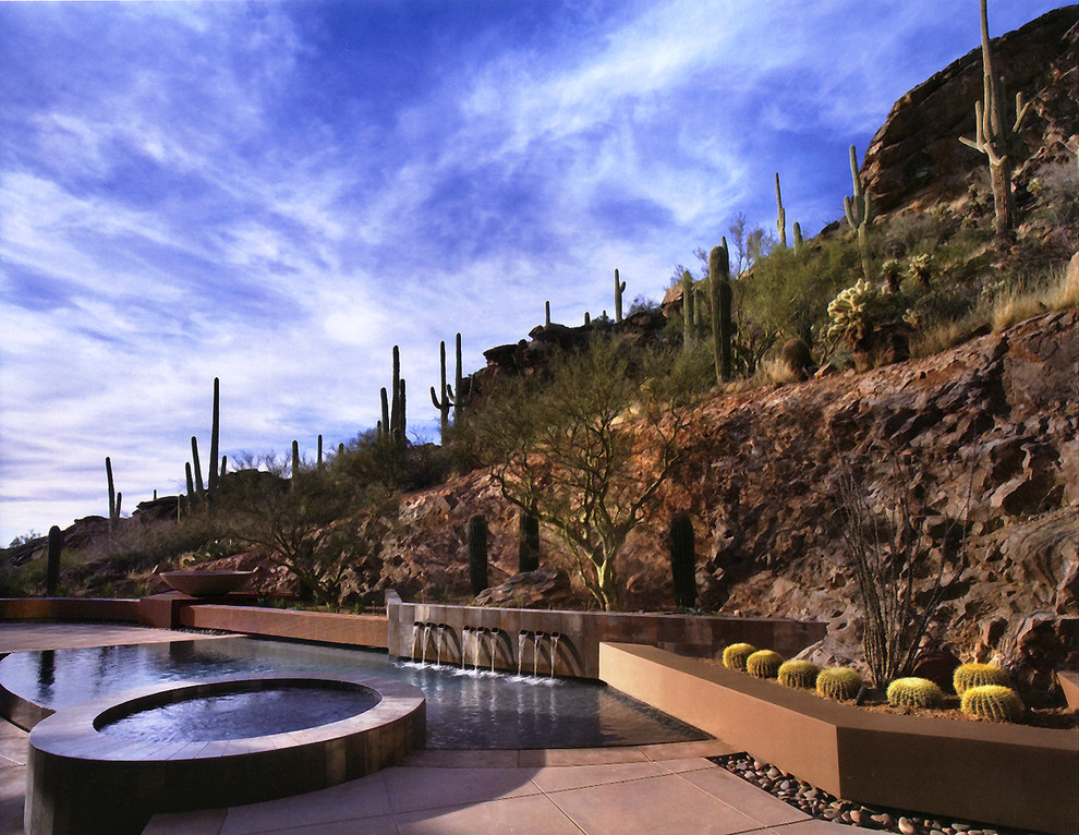 Photo of a custom-shaped pool in Phoenix with a water feature.