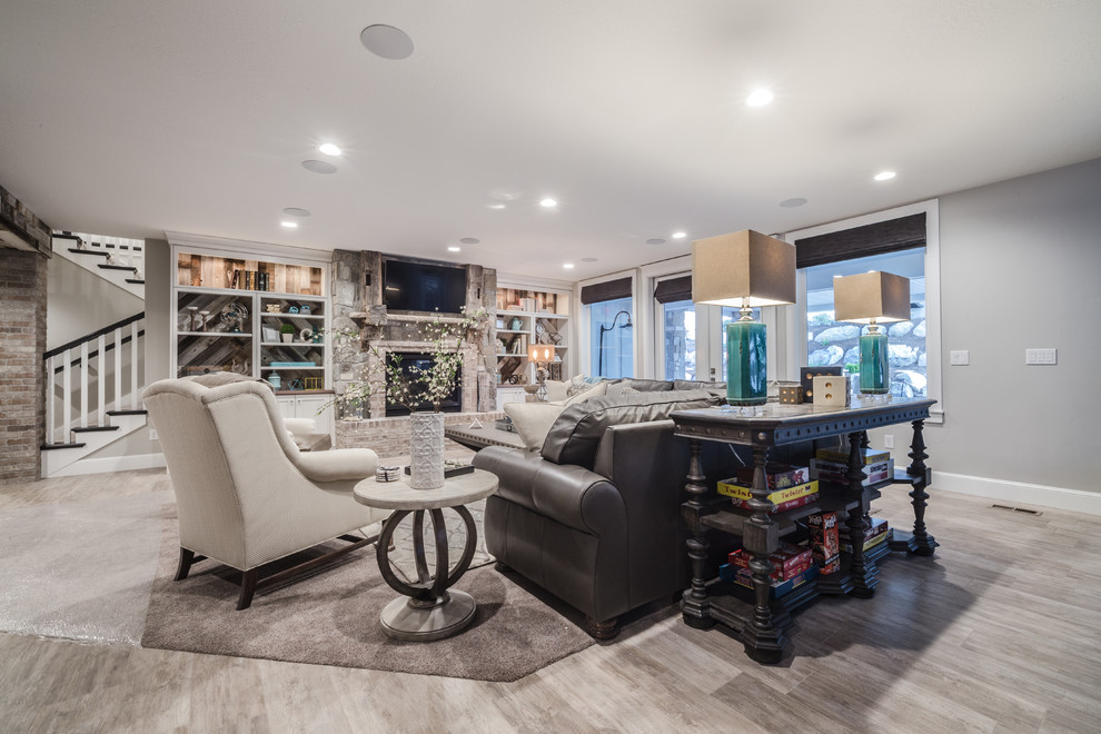 Inspiration for a mid-sized arts and crafts walk-out basement in Salt Lake City with grey walls, ceramic floors, a standard fireplace, a stone fireplace surround and beige floor.