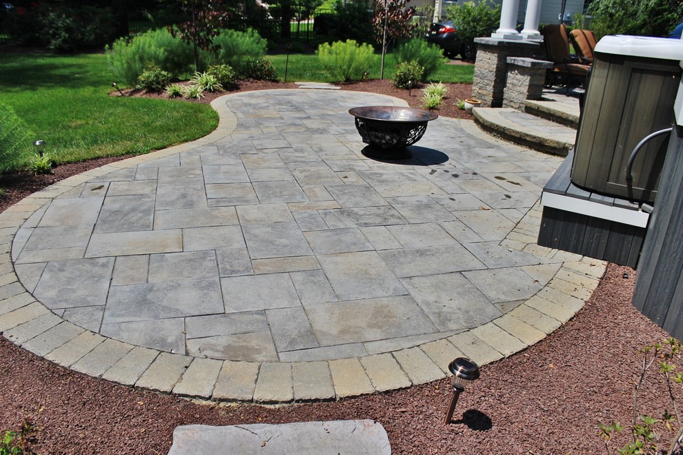 Large traditional backyard patio in Philadelphia with a water feature, natural stone pavers and a roof extension.