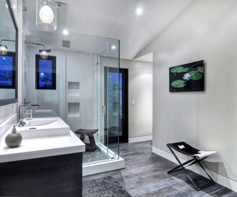 Photo of a mid-sized contemporary master bathroom in Orange County with flat-panel cabinets, medium wood cabinets, a corner tub, a corner shower, a one-piece toilet, gray tile, stone tile, white walls, concrete floors, a vessel sink and granite benchtops.