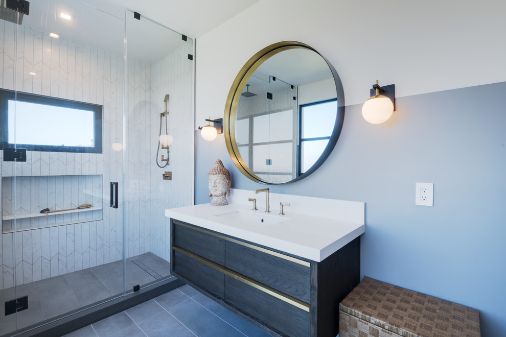 Alcove shower - contemporary 3/4 white tile gray floor alcove shower idea in Los Angeles with flat-panel cabinets, dark wood cabinets, blue walls, an undermount sink, a hinged shower door and white countertops