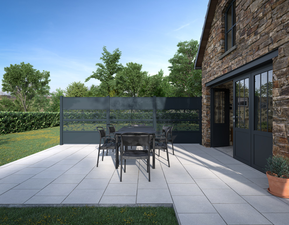This is an example of a medium sized rural back patio with a potted garden, tiled flooring and no cover.