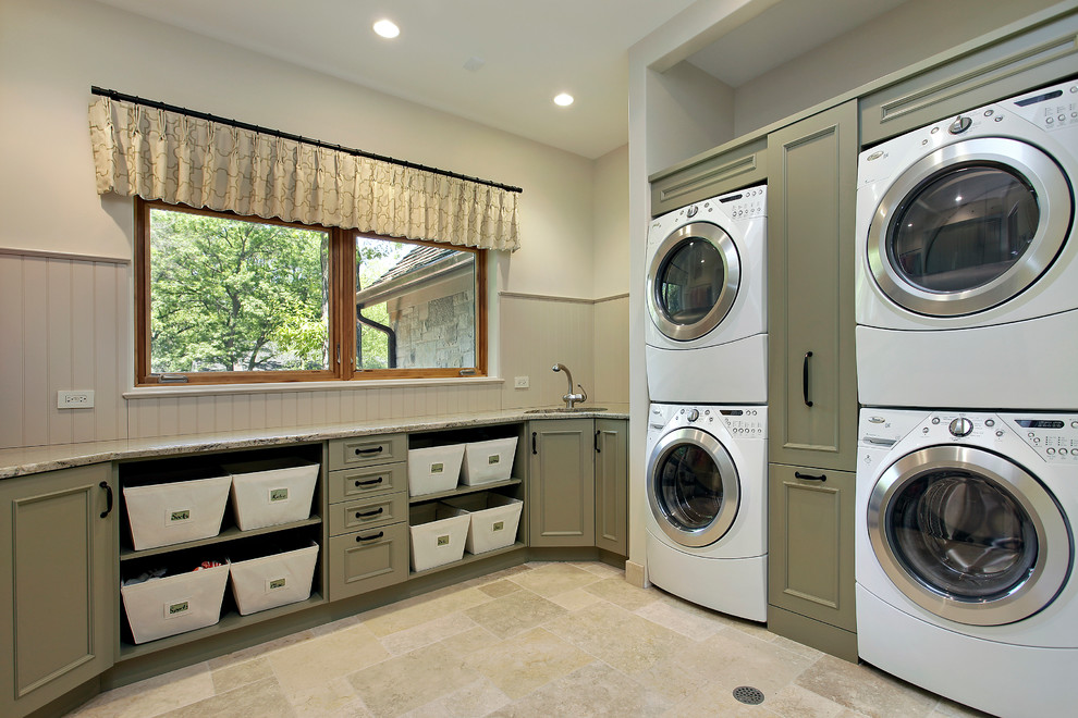 Inspiration for a traditional laundry room in Chicago with green cabinets, a stacked washer and dryer, beige floor and beige benchtop.
