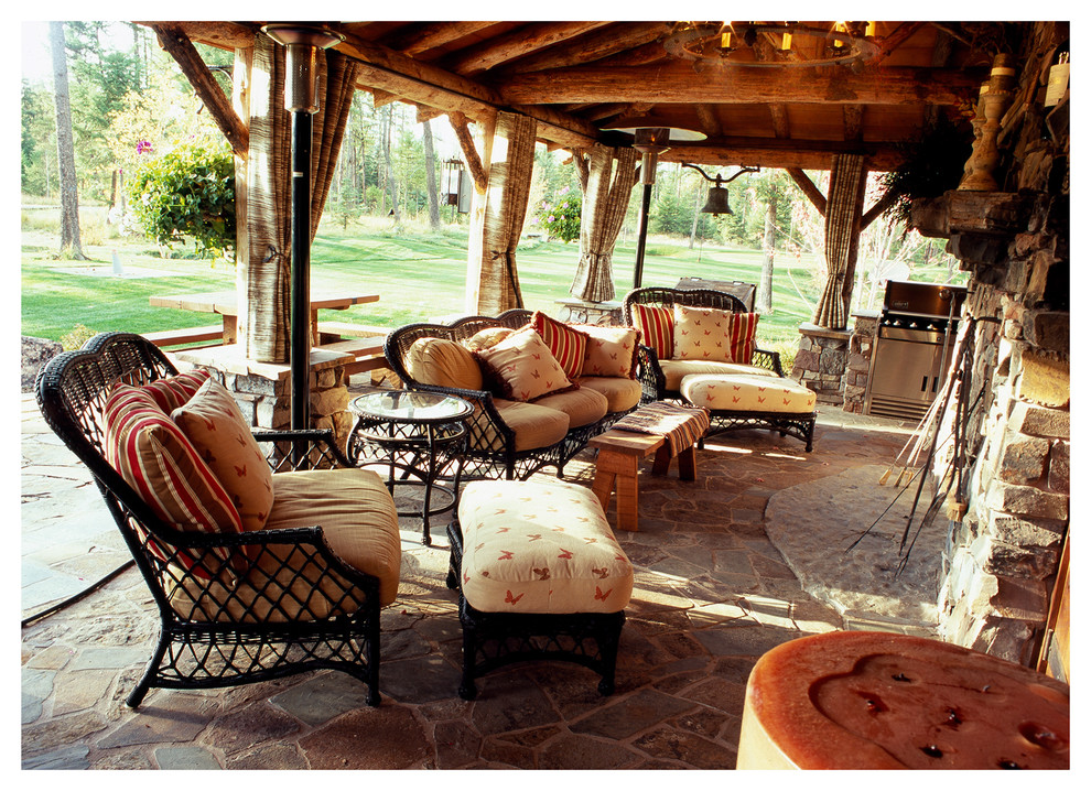 Small mountain style backyard stone patio kitchen photo with a gazebo