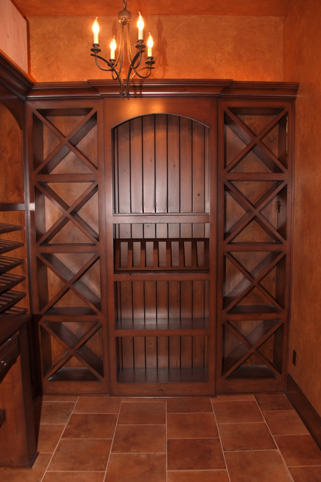 Example of a mid-sized classic ceramic tile and red floor wine cellar design in Other with storage racks