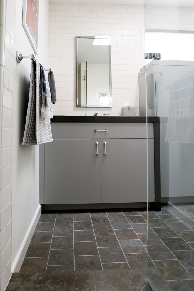 Photo of a mid-sized industrial 3/4 bathroom in San Diego with flat-panel cabinets, grey cabinets, marble benchtops, white tile, ceramic tile, a corner shower, a two-piece toilet, an undermount sink, white walls and limestone floors.
