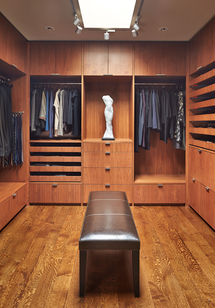 Design ideas for a large contemporary men's dressing room in Seattle with flat-panel cabinets, medium wood cabinets and medium hardwood floors.