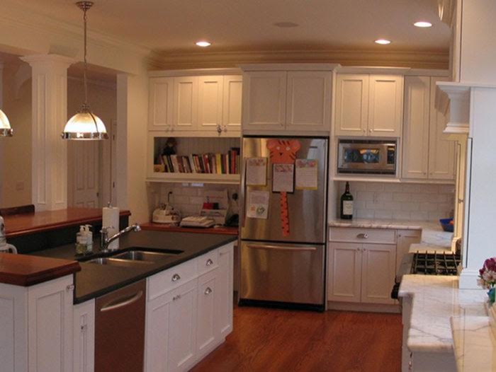Example of a large transitional l-shaped medium tone wood floor enclosed kitchen design with a double-bowl sink, beaded inset cabinets, white cabinets, marble countertops, white backsplash, subway tile backsplash, stainless steel appliances and an island