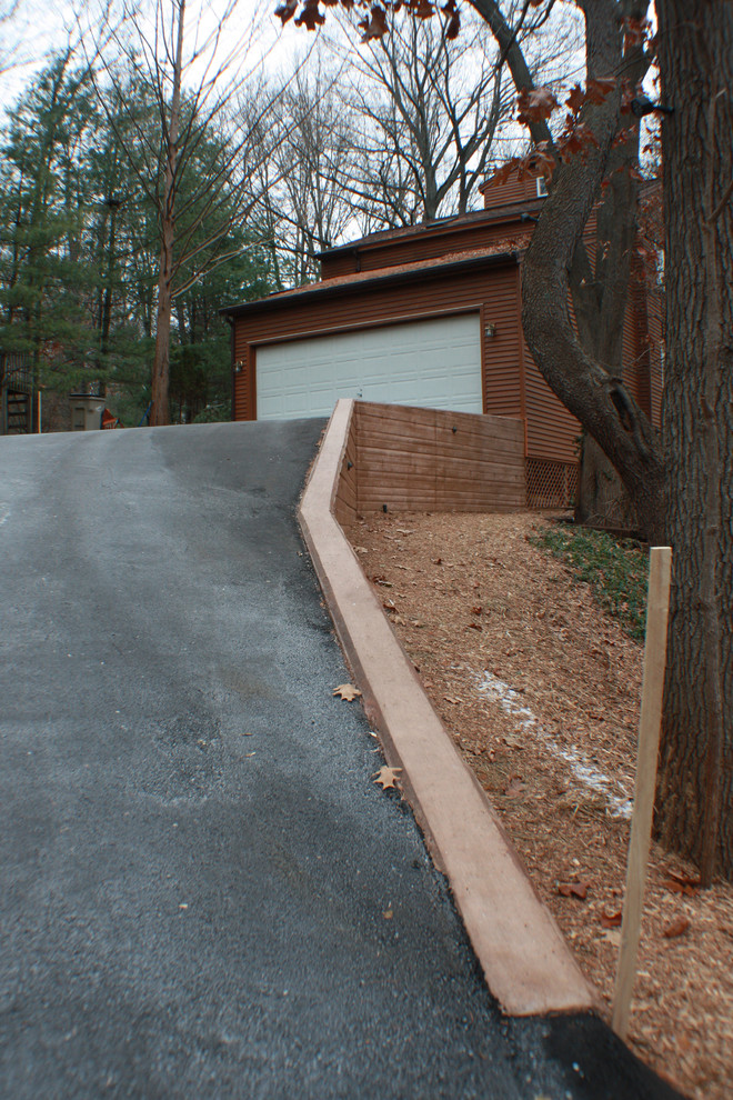 Mid-sized arts and crafts front yard partial sun driveway in Grand Rapids with a retaining wall and concrete pavers.